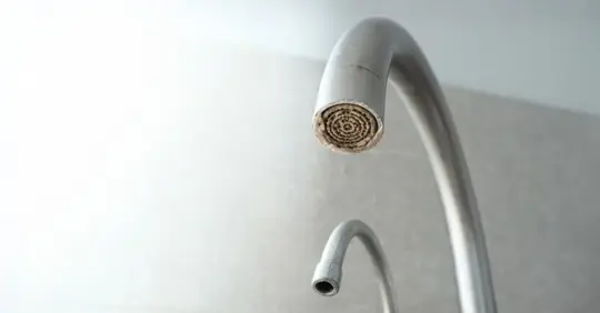 Faucet with white mineral deposits